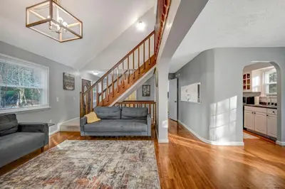 a living room with a couch and a staircase at Pocono Chalet Towamensing with Hot Tub Lake and Pool in Albrightsville