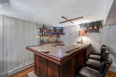 a bar with leather chairs in a room at Lake harmony estates beach and lake access in Lake Harmony
