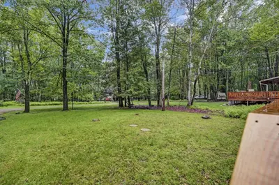 an empty park with a bench and trees at cozy home in arrowhead lake with huge screened in porch beach and lake and playground in Arrowhead Lake