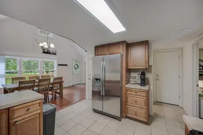 a kitchen with a stainless steel refrigerator and a dining room at cozy home in arrowhead lake with huge screened in porch beach and lake and playground in Arrowhead Lake