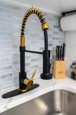 a kitchen sink with a black and gold faucet at Modern Studio - Parking Available - 15 min NYC in Jersey City