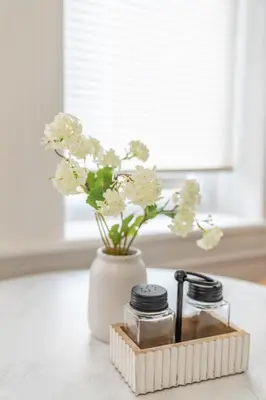 a white vase with flowers in it on a counter at Modern Studio - Parking Available - 15 min NYC in Jersey City