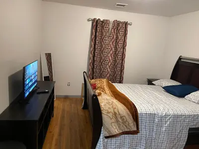 a bedroom with a bed and a flat screen tv at Peculiar 153 in Newark