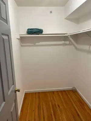 an empty closet with white walls and a wooden floor at Peculiar 153 in Newark