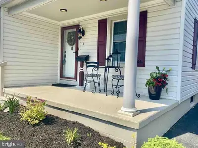 a front porch with two chairs and a table at Family Home in mainheim PA close to atractions in Manheim