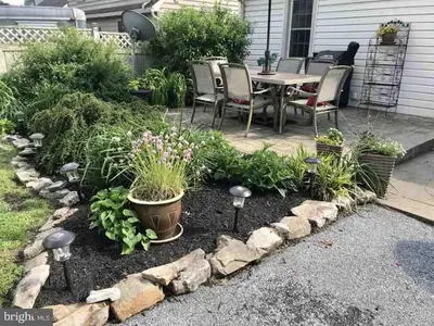 a patio with a table and chairs and plants at Family Home in mainheim PA close to atractions in Manheim