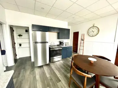 a kitchen with a table and a clock on the wall at Cozy Lancaster Apartment Near Attractions in Lancaster