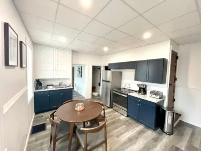 a kitchen with blue cabinets and a table and chairs at Cozy Lancaster Apartment Near Attractions in Lancaster