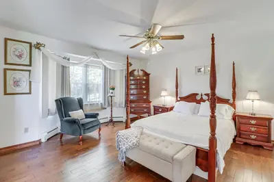 a bedroom with a bed and a chair and a ceiling fan at Game Room! Lake-View Gem 7 Mi to Camelback Slopes in Long Pond