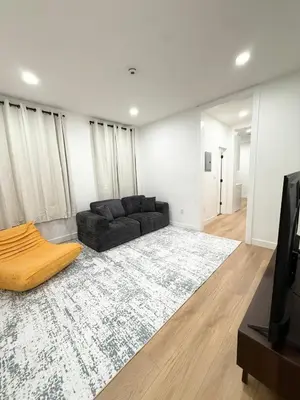 a living room with a black couch and a rug at The View - Direct Bus Time Square NYC Breakfast Included - A in Jersey City