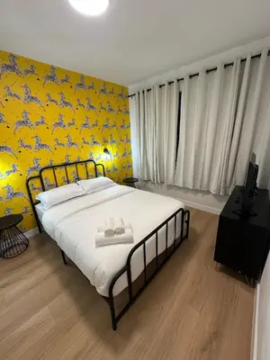 a bedroom with a large bed with a yellow wall at The View - Direct Bus Time Square NYC Breakfast Included - C in Jersey City