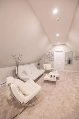 a white living room with white chairs and tables at Bayonne Bay Inn in Bayonne