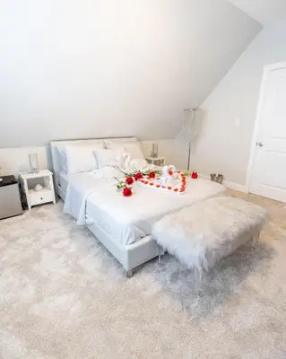 a bedroom with a white bed with flowers on it at Bayonne Bay Inn in Bayonne