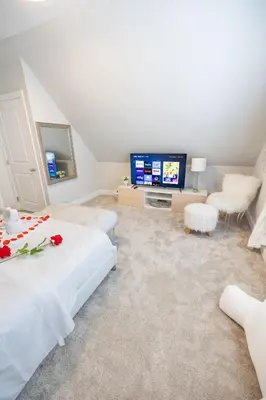 a living room with a bed and a tv at Bayonne Bay Inn in Bayonne