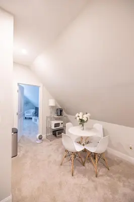 a white dining room with a table and chairs at Bayonne Bay Inn in Bayonne