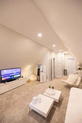 a large living room with a large screen tv at Bayonne Bay Inn in Bayonne