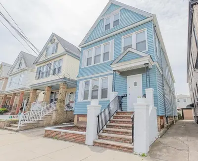 a blue house on a street with two houses at Bayonne Bay Inn in Bayonne