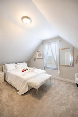 a white bedroom with a bed and a window at Bayonne Bay Inn in Bayonne