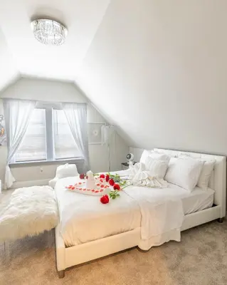 a bedroom with a white bed with flowers on it at Bayonne Bay Inn in Bayonne