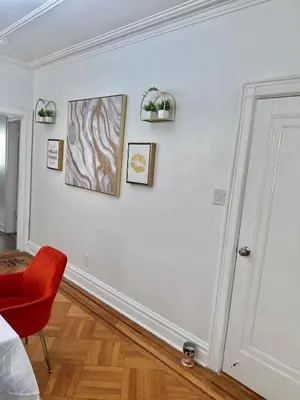 a white room with a red chair and pictures on the wall at Heaven on earth in Bayonne