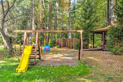 a playground with a slide and a swing at Charming Forest Cabin with a Hammock near Delaware Water Gap National Recreation Area, Pennsylvania in Canadensis