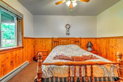 a bedroom with a bed with wooden walls and a window at Charming Forest Cabin with a Hammock near Delaware Water Gap National Recreation Area, Pennsylvania in Canadensis