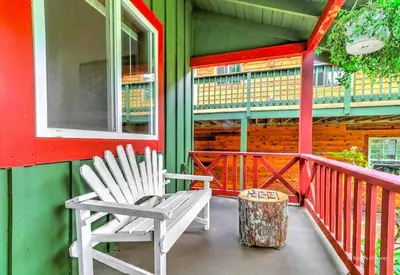 a pair of white chairs sitting on the porch of a house at Charming Forest Cabin with a Hammock near Delaware Water Gap National Recreation Area, Pennsylvania in Canadensis