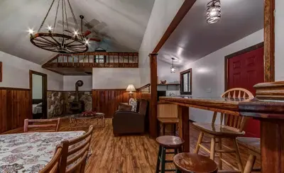 a kitchen and living room with a table and chairs at Cozy Cottage Rental with Small Private Pond in Canadensis, Pennsylvania in Canadensis