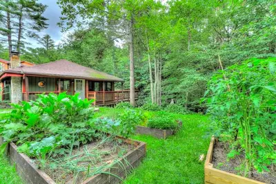 a house in the middle of a yard with plants at Cozy and Secluded Cabin with a Fireplace in the Poconos Mountains of Pennsylvania in Canadensis