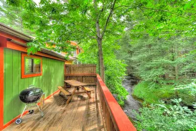 a deck with a picnic table and a grill at Cozy and Secluded Cabin with a Fireplace in the Poconos Mountains of Pennsylvania in Canadensis