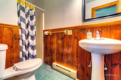 a bathroom with a sink and a toilet and a mirror at Cozy and Secluded Cabin with a Fireplace in the Poconos Mountains of Pennsylvania in Canadensis