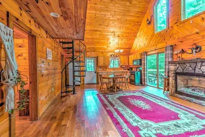 a living room with a fireplace and a table at Idyllic Log Cabin Rental with a Porch in the Poconos of Pennsylvania in Canadensis