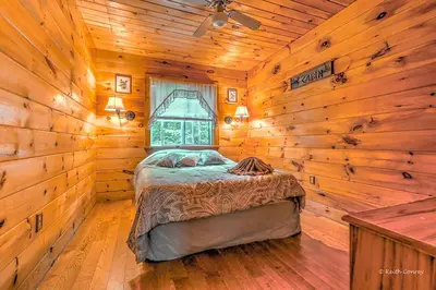 a bedroom with a bed in a wooden room at Idyllic Log Cabin Rental with a Porch in the Poconos of Pennsylvania in Canadensis