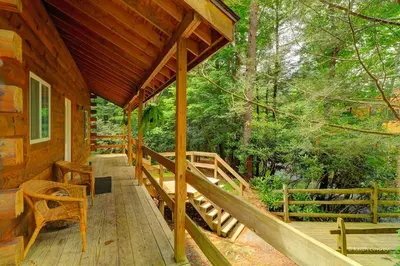 a porch of a cabin in the woods at Idyllic Log Cabin Rental with a Porch in the Poconos of Pennsylvania in Canadensis