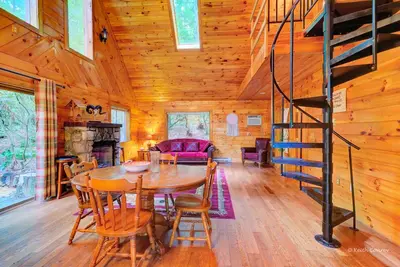 a dining room with a table and a staircase in a cabin at Idyllic Log Cabin Rental with a Porch in the Poconos of Pennsylvania in Canadensis