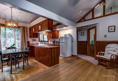 a kitchen and dining room with a white refrigerator at Private Cabin Rental with Wood-Burning Fireplace in Canadensis, Pennsylvania in Canadensis