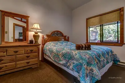 a bedroom with a bed and a dresser and a mirror at Private Cabin Rental with Wood-Burning Fireplace in Canadensis, Pennsylvania in Canadensis