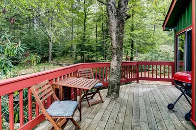 a wooden deck with a picnic table and a grill at Private Cabin Rental with Wood-Burning Fireplace in Canadensis, Pennsylvania in Canadensis