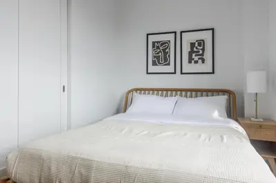 a bed in a bedroom with two pictures on the wall at Blueground Bloomingdale fitness center nr Central Park NYC-1869 in New York