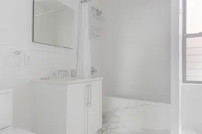 a white bathroom with a sink and a mirror at Blueground Bloomingdale fitness center nr Central Park NYC-1869 in New York