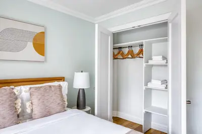 a white bedroom with a bed and a lamp at Blueground Manhattan Valley fitness nr Central Park NYC-1101 in New York