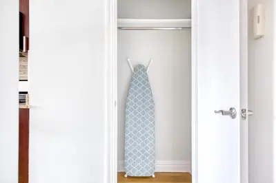 a tie hanging on a door in a closet at Blueground Manhattan Valley fitness nr Central Park NYC-1101 in New York