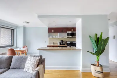 a living room with a couch and a kitchen at Blueground Manhattan Valley fitness nr Central Park NYC-1101 in New York