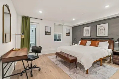 a bedroom with a large bed and a desk at SLEEP 8 Outdoor Patio-Old City- 2 NEW Townhouses in Philadelphia