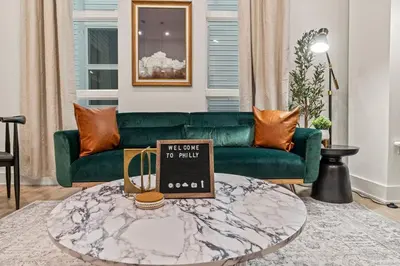 a living room with a green couch and a coffee table at SLEEP 8 Outdoor Patio-Old City- 2 NEW Townhouses in Philadelphia