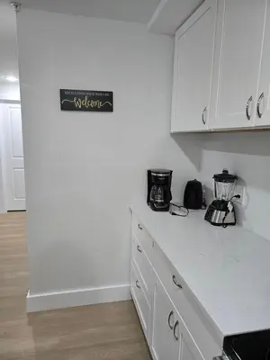 a kitchen with white cabinets and a counter top at Tkc Villa in Newark