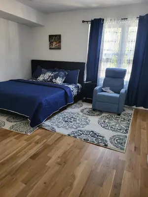 a bedroom with a bed and a chair at Tkc Villa in Newark