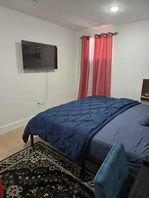 a bedroom with a bed and a flat screen tv at Tkc Villa in Newark