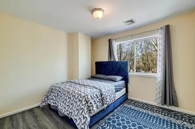 a bedroom with a blue bed and a window at Pocono Home Hot tub Camelback Lake Pool in Albrightsville