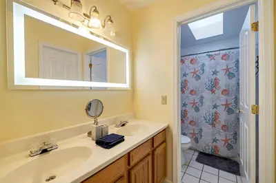 a bathroom with a sink and a mirror and a shower at Pocono Home Hot tub Camelback Lake Pool in Albrightsville